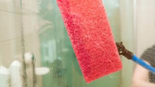 A window being cleaned with a red wiper.