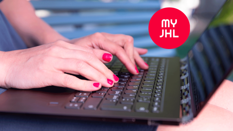 Hands are typing on the keyboard of a black notebook computer. In the top right corner there is a red circle with text MYJHL.