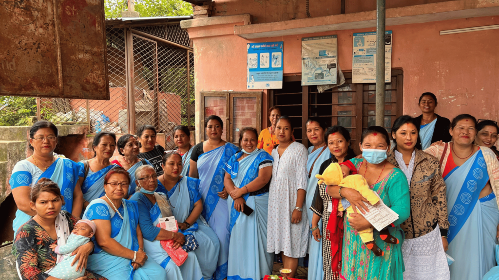20 nepalilaista terveysvapaaehtoista, joista kaikki naisia, työpaikallaan Kathmandussa. Kaksi naisista pitelee vauvaa sylissään.