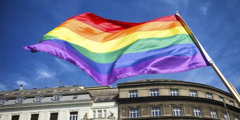 Pride-lippu liehuu, taustalla rakennus