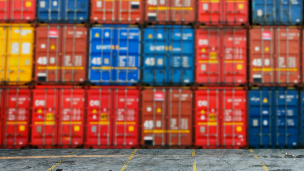 Colourful shipping containers on asphalt.